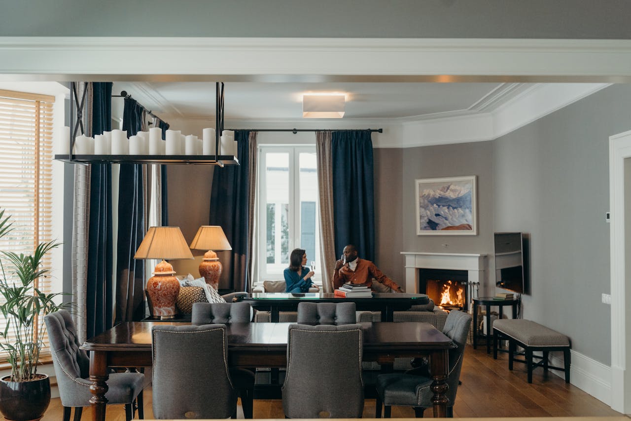 A couple relaxes in a luxurious living room with elegant decor, warm fireplace, and stylish furnishings.